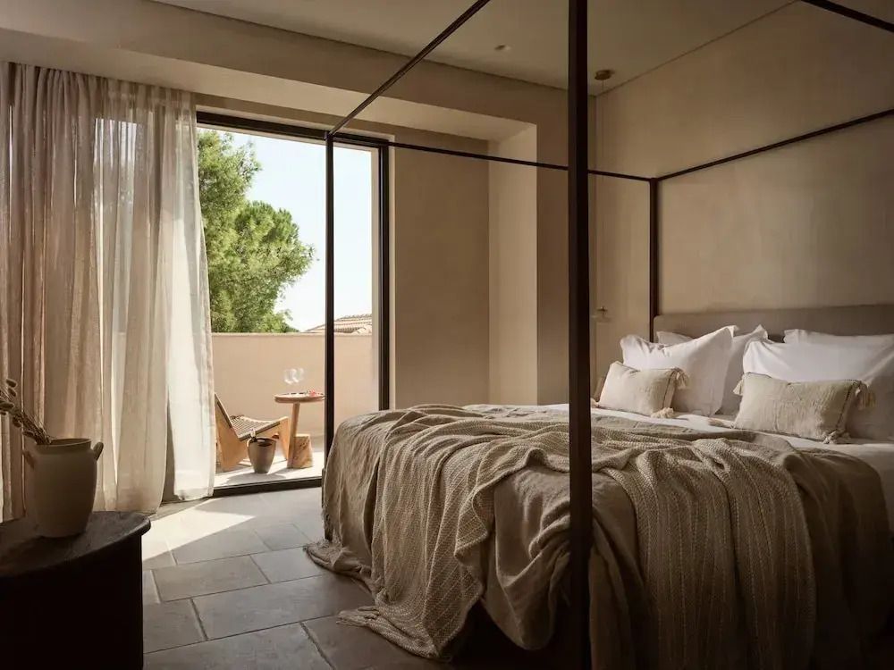 Schlafzimmer mit Himmelbett und geöffnetem Zugang zur Terrasse