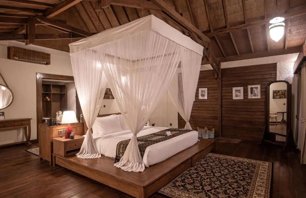 Deluxe Zimmer mit Himmelbett und Holzdekor im Plataran Komodo Resort