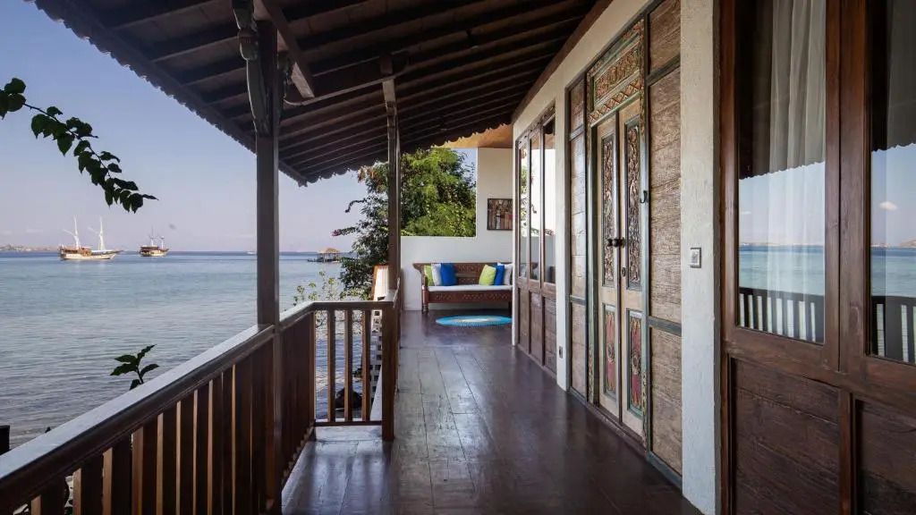 Holzveranda am Wasser mit komfortabler Sitzgelegenheit im Plataran Komodo Resort