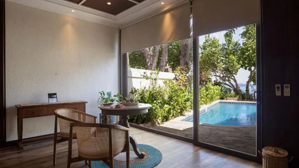 Sitzbereich mit Blick auf den privaten Pool und Grünflächen