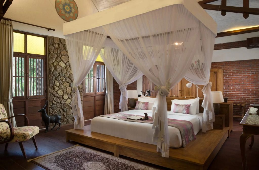 Luxuriöses Schlafzimmer mit Himmelbett und rustikaler Steinwand