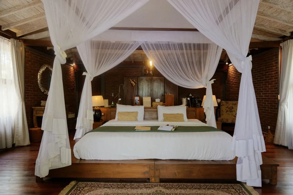 Luxuriöses Doppelbett mit Himmelbettvorhängen in einer eleganten Villa