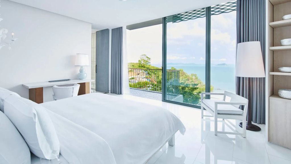 Helles Schlafzimmer mit Meerblick durch große Fenster