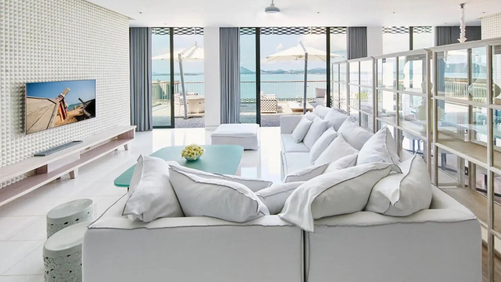 Großzügiger Wohnbereich mit Blick auf das Meer und weißen Sofas