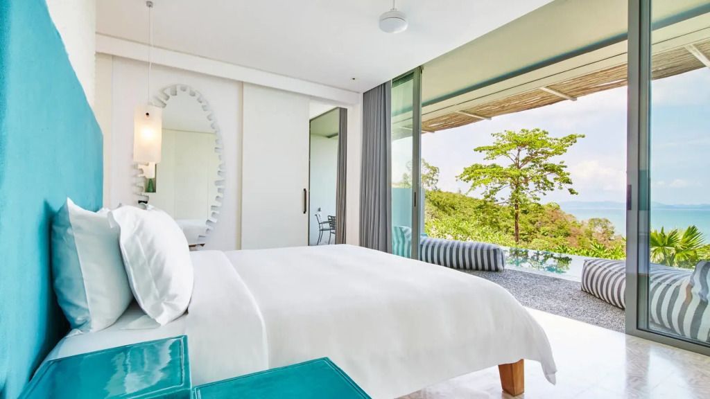 Helles Zimmer mit Doppelbett und großem Fenster mit Blick ins Grüne