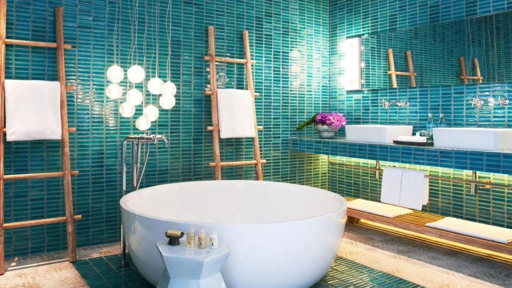 Luxuriöses Badezimmer mit runden Badewanne in türkis gefliesten Raum