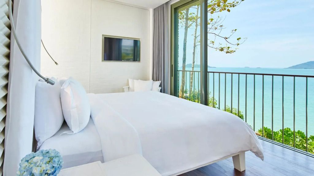 Geräumiges Schlafzimmer mit weißem Bett und Meerblick im COMO Point Yamu Hotel