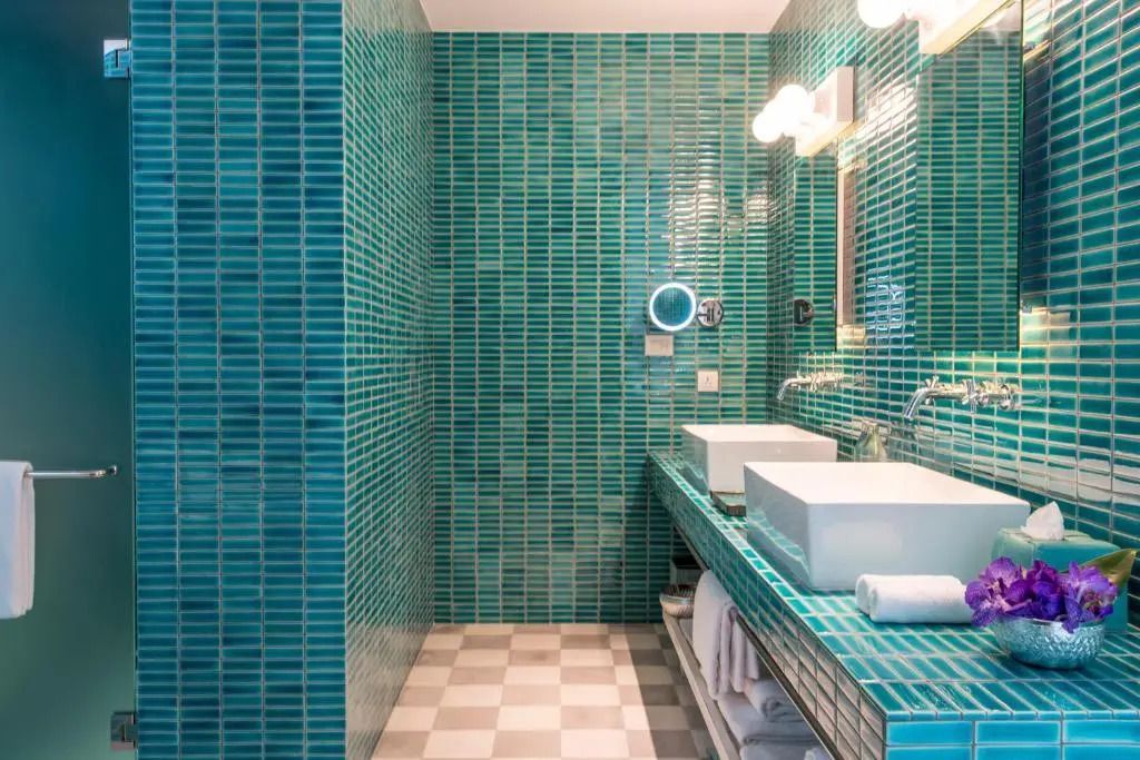 Badezimmer mit türkisfarbenen Fliesen und zwei modernen Waschbecken