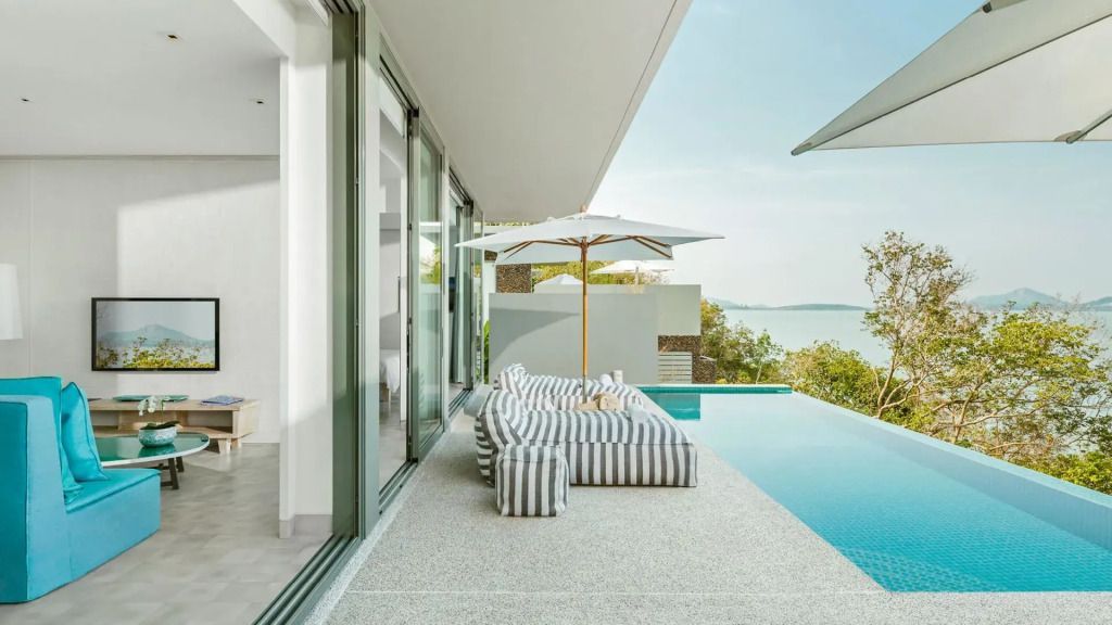 Terrasse mit gestreiften Liegen und Blick auf den Infinity Pool und das Meer