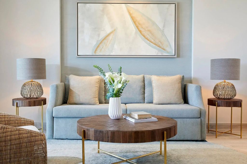 Komfortable Sitzecke mit grauem Sofa und rundem Holztisch.