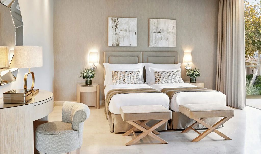 Elegantes Schlafzimmer mit zwei Einzelbetten in neutralen Tönen und stilvollen Akzenten