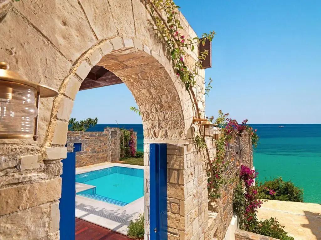 Steinbogen mit Blick auf Pool und Meer im Hintergrund