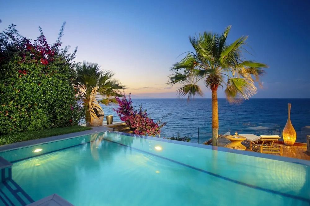 Pool mit wunderschönem Meerblick umgeben von Palmen