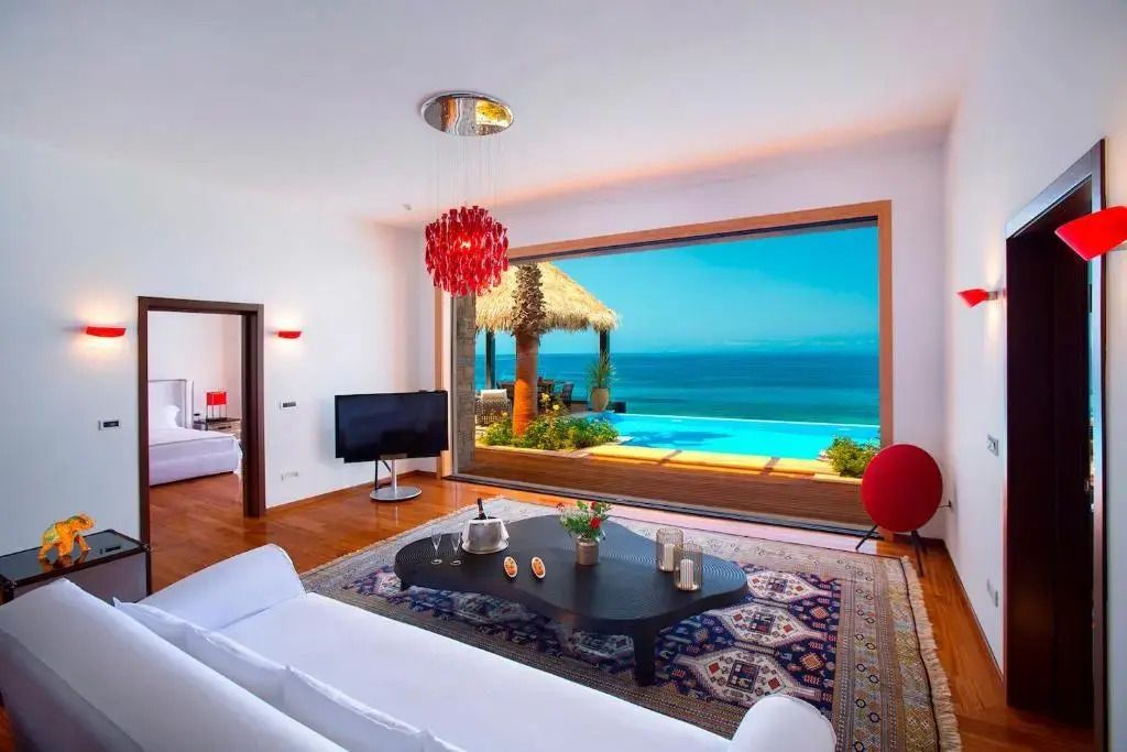Geräumiges Wohnzimmer mit großem Fenster zum Meer
