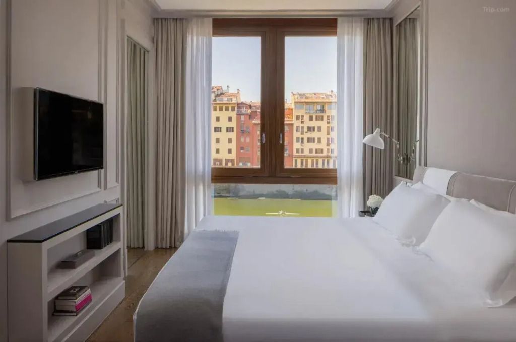 Elegantes Schlafzimmer mit Blick auf den Arno und die farbenfrohen Gebäude am Flussufer