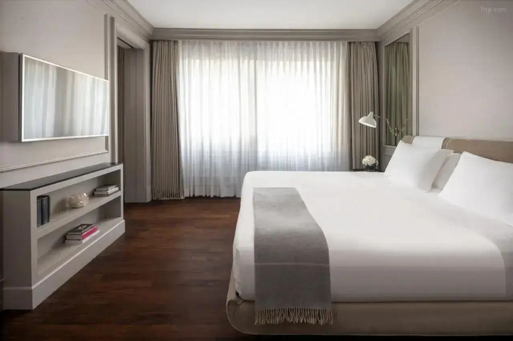 Elegantes Schlafzimmer mit großem Doppelbett und weichen Textilien in neutralen Farben