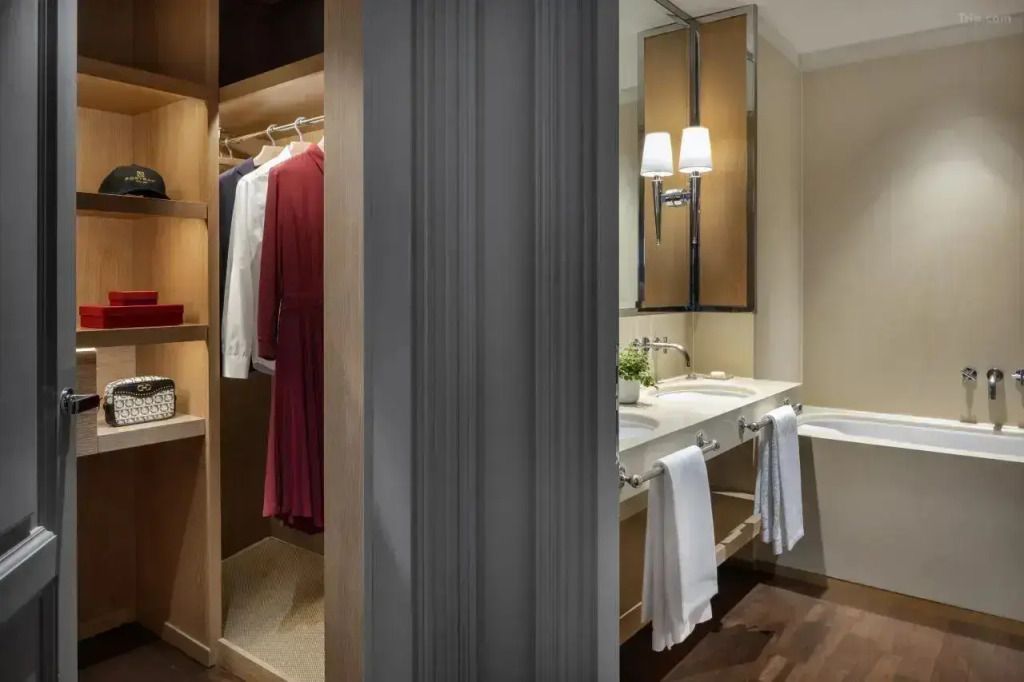 Offener Kleiderschrank im Hotelzimmer mit Einblick ins Badezimmer