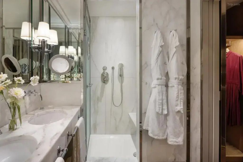 Luxuriöses Marmorbad mit Dusche und flauschigen Bademänteln.