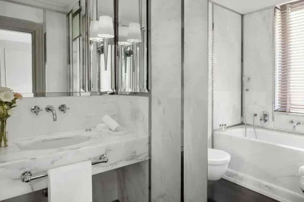 Modernes Badezimmer mit Marmorverkleidung und großzügiger Badewanne.