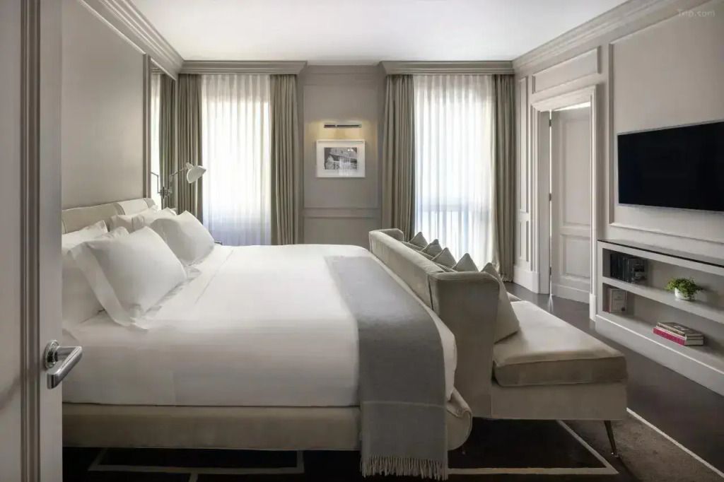 Elegantes Schlafzimmer mit großem Doppelbett und Tageslicht.