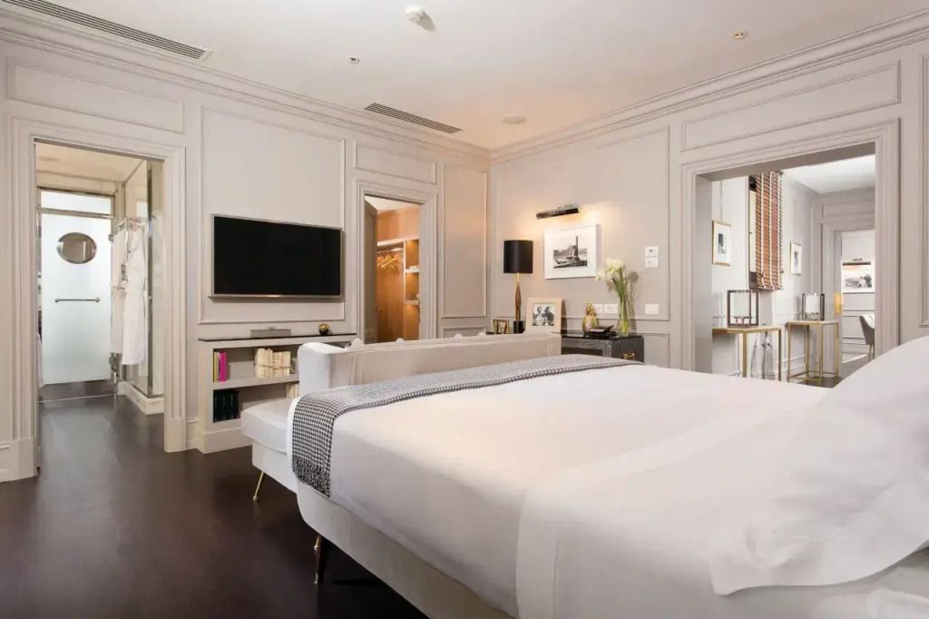 Geräumiges Zimmer mit großem Bett und Flachbild-TV an der Wand.