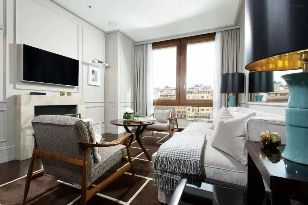 Geräumiges Wohnzimmer mit Sesseln und einem großen Fenster mit Flussblick.