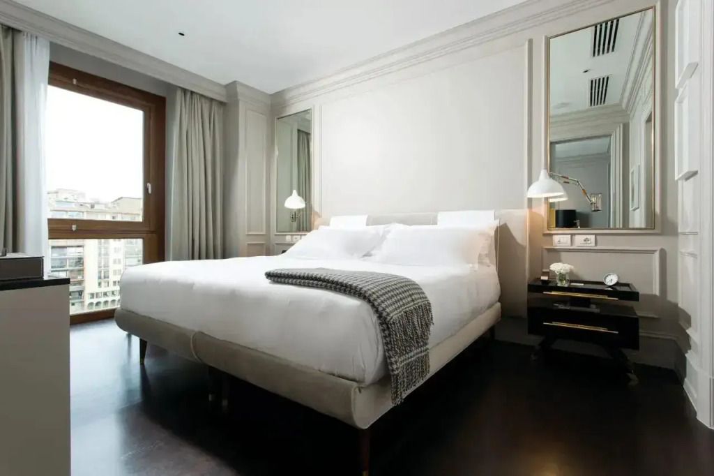 Elegantes Schlafzimmer mit zwei einzelnen Betten und einem großen Fenster mit Flussblick.