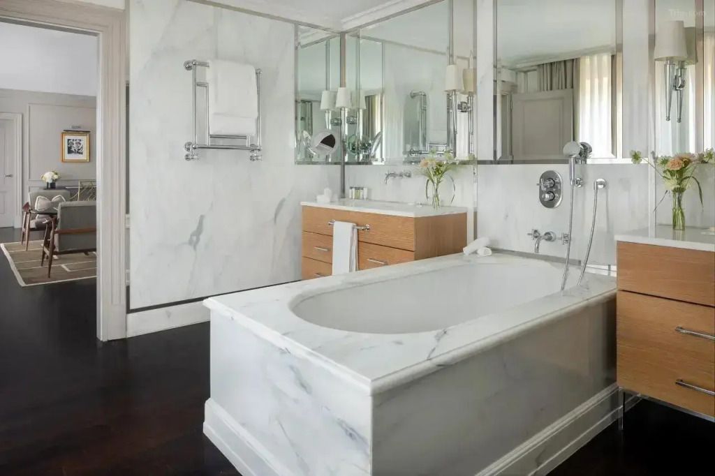 Helles Badezimmer mit marmorierter Badewanne und eleganten Armaturen