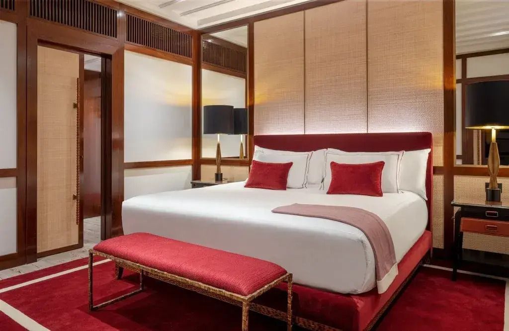 Helles Schlafzimmer mit rotem Samtdekor und Doppelbett in der Executive Suite