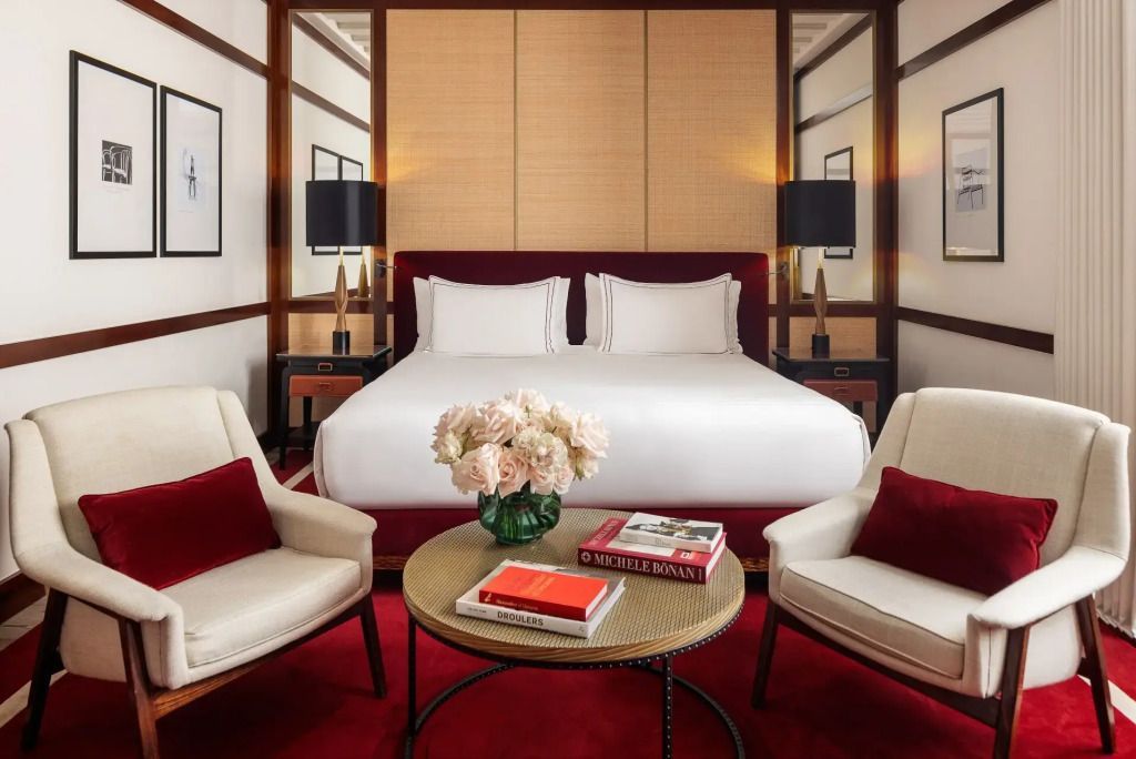 Elegantes Doppelbettzimmer mit rotem Teppich und stilvollen Sesseln