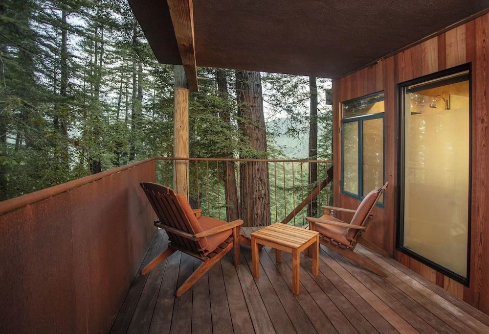 Holzbalkon mit Sitzgelegenheiten und Baum-Bergblick