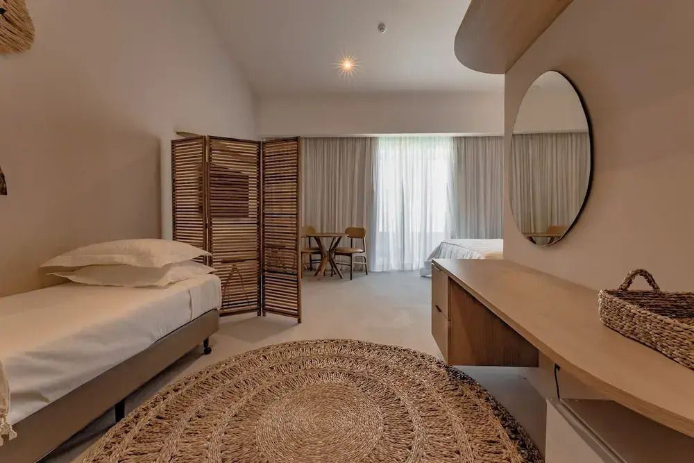 Elegantes Hotelzimmer mit runden Teppich und hellem Interieur