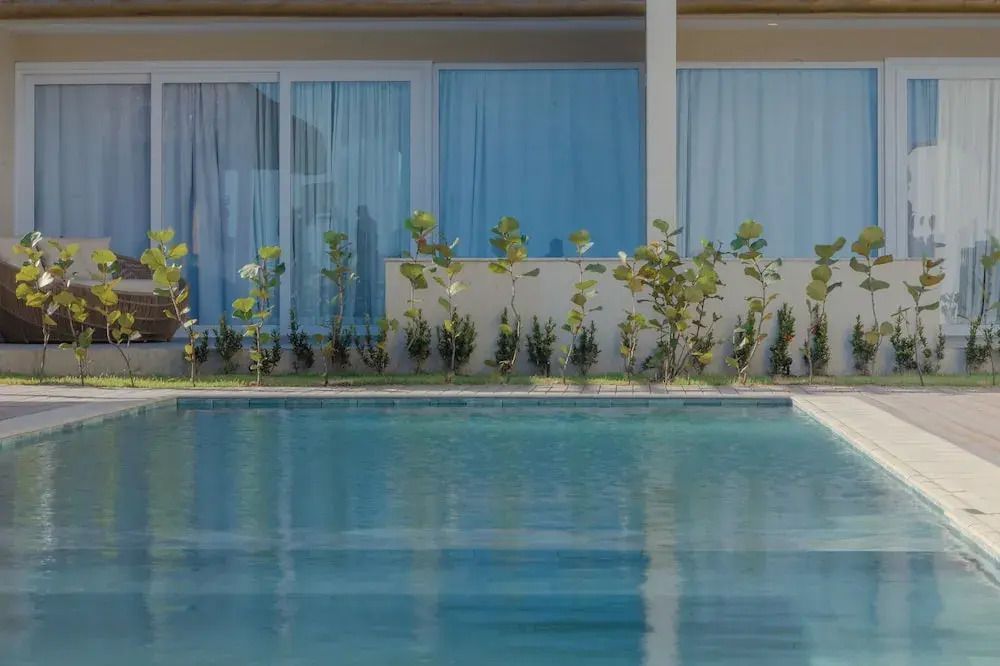 Außenansicht eines Pools vor einem Gebäude mit modernen Glastüren