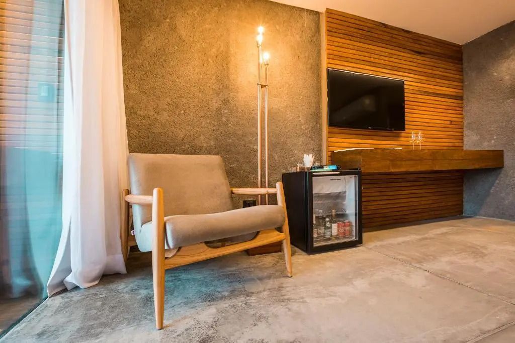Gemütlicher Sitzbereich mit Sessel und Minibar im Bungalow Penthouse