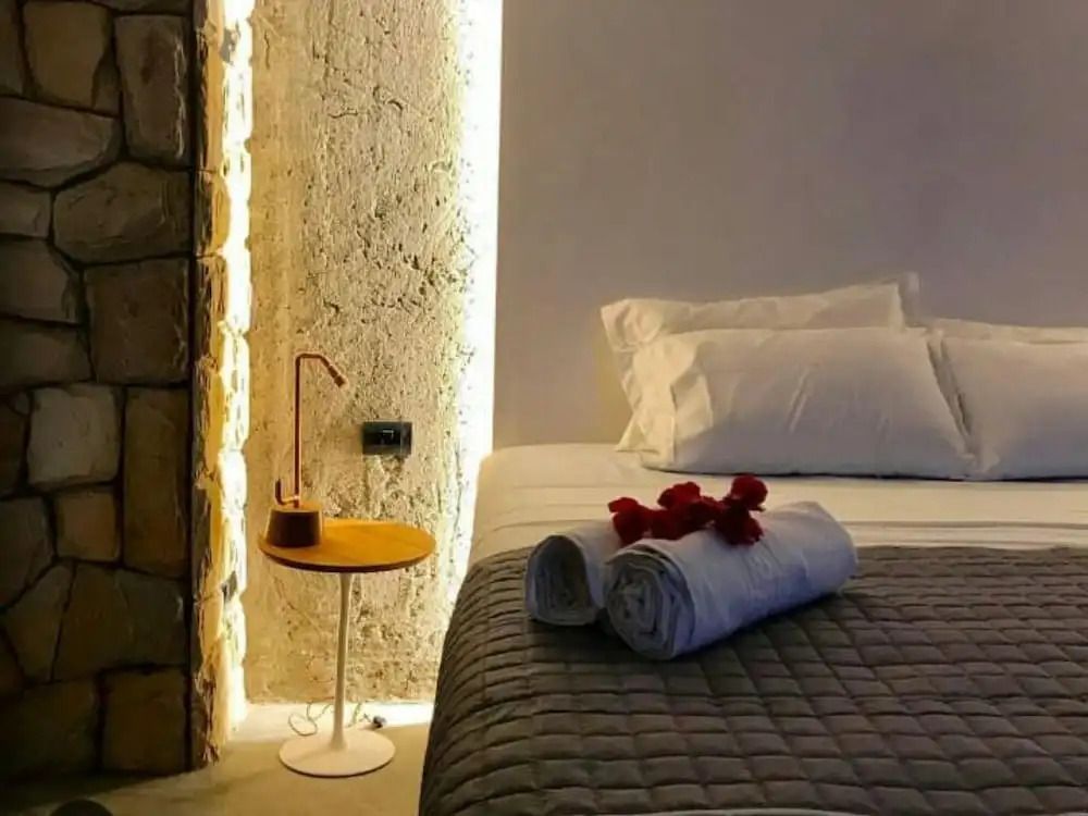 Modernes Zimmer mit beleuchteter Wand und dekorativen Handtüchern auf dem Bett