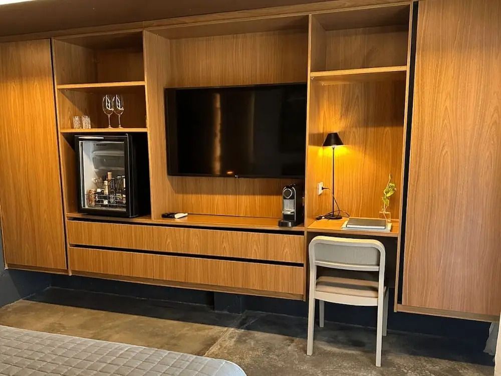 Zimmer mit Holzregalen, Flachbildfernseher und Schreibtisch