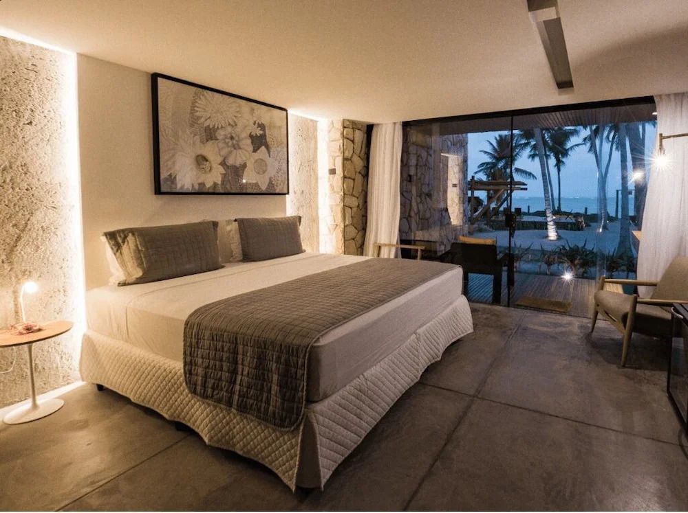 Großes Bett im Standardzimmer mit Blick auf die Terrasse und das Meer