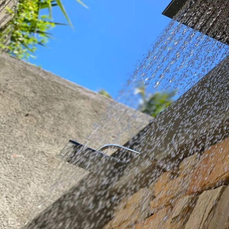 Offene Dusche im Freien mit Blick auf blauen Himmel und Pflanzen