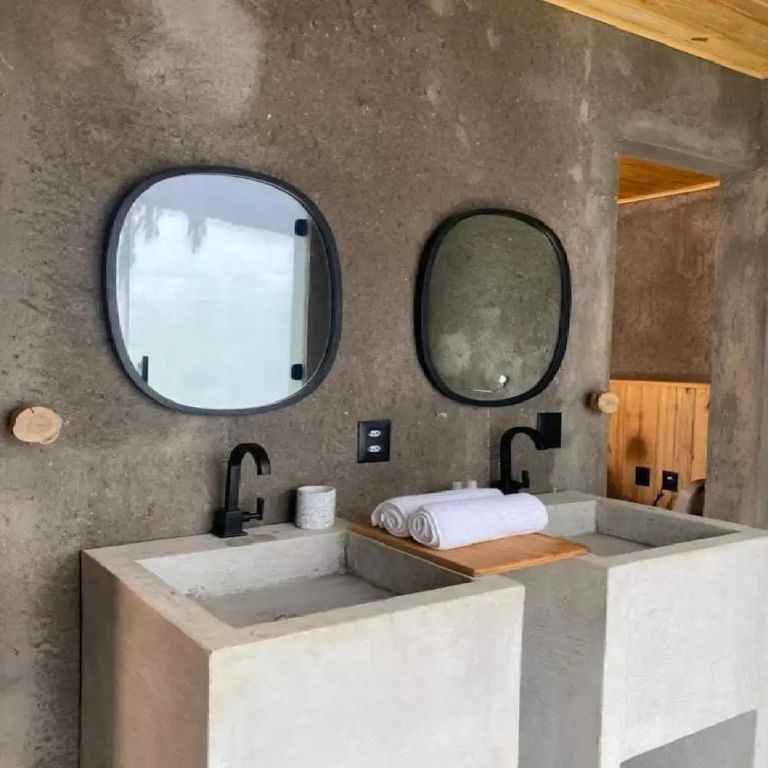 Waschbecken aus Beton mit Holzdetail und Spiegel