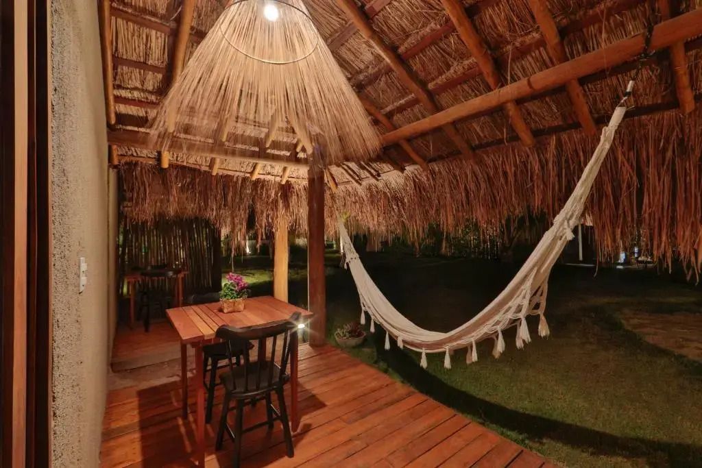 Überdachte Terrasse mit Tisch und Hängematte im Bungalow