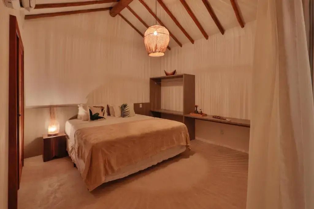 Zimmer mit Doppelbett und rustikalen Holzbalken