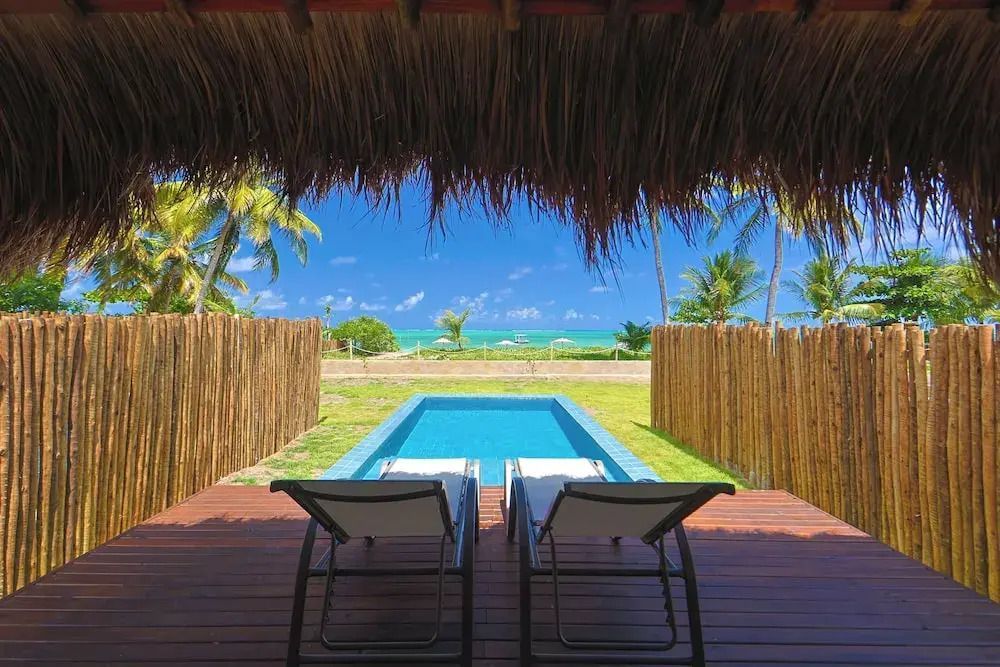 Blick vom Bungalow aufs Meer mit privatem Pool und Liegestühlen