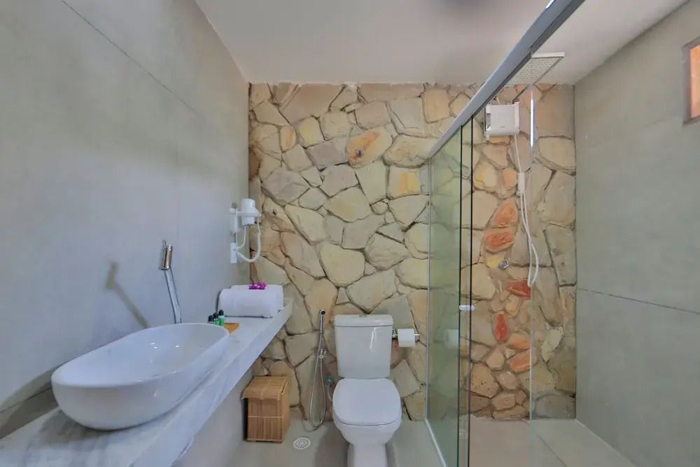 Modernes Badezimmer mit Natursteinwand und begehbarer Dusche