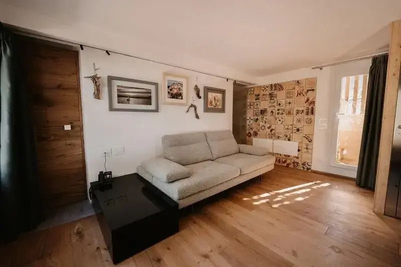 Lichtdurchfluteter Wohnraum mit modernem Sofa und dekorierter Wand