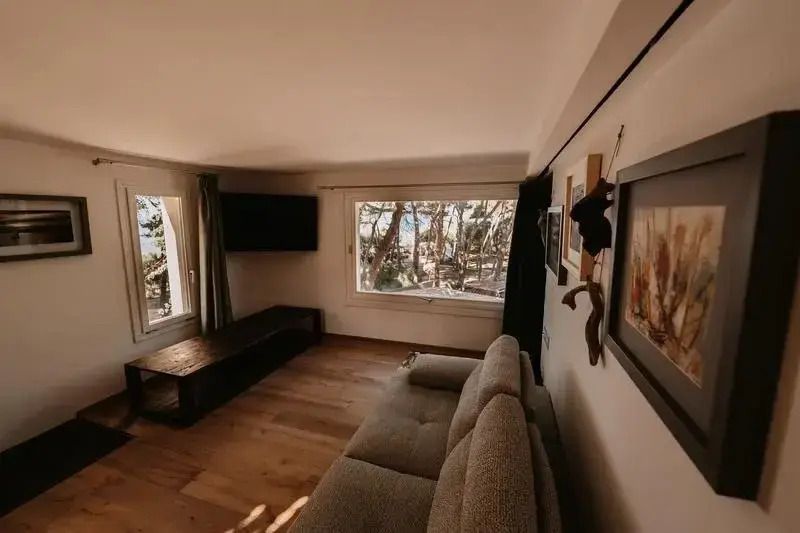 Gemütliche Sitzecke der Suite mit Blick aus großen Fenstern auf Natur