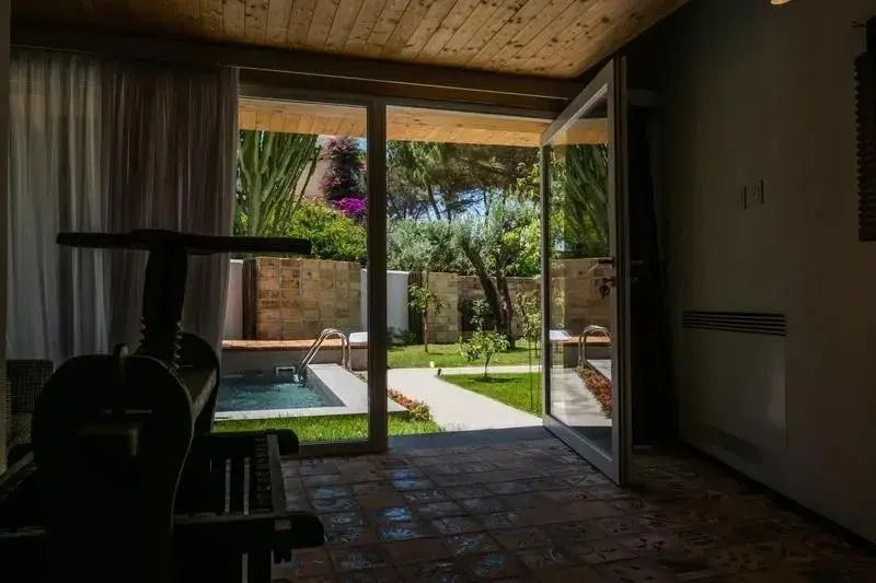 Blick vom Innenraum auf den privaten Pool und Garten