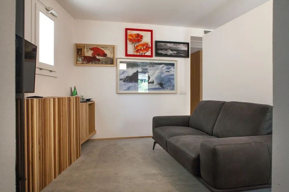 Gemütlicher Wohnbereich mit grauem Sofa und Kunstwerken