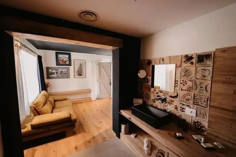 Luxuriöse Suite mit stilvollem Badezimmer und gemütlicher Sitzecke.