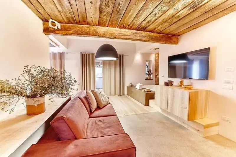 Moderne Suite mit komfortabel eingerichtetem Wohnbereich und großem Fernseher.