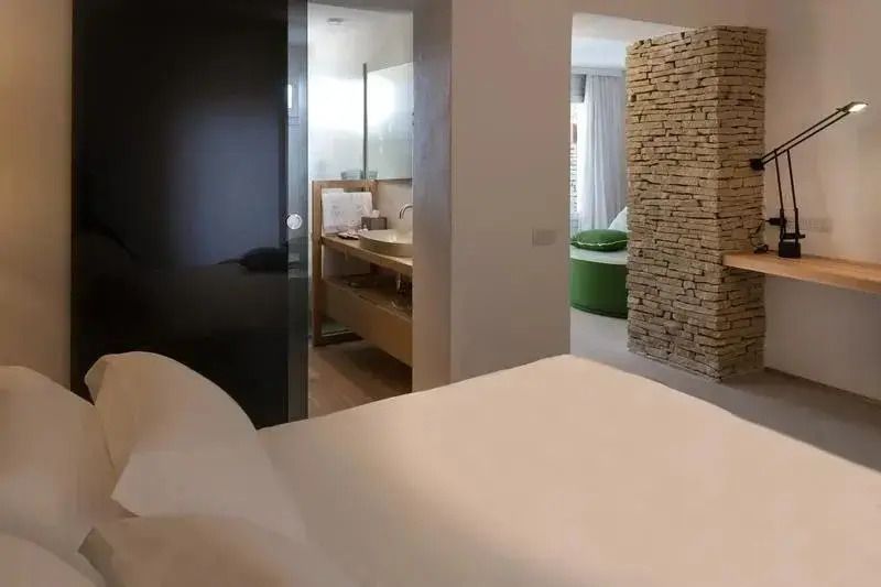 Zimmer mit offenem Badezimmerdesign und Blick auf elegante Steinmauer